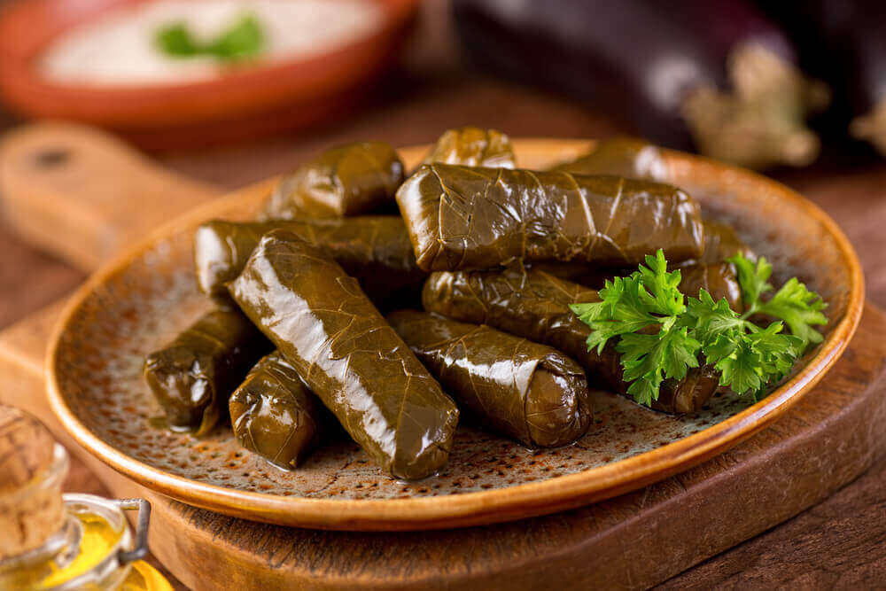 A plate of delicious stuffed grape leaves with parsley garnish. vegetarian holiday
