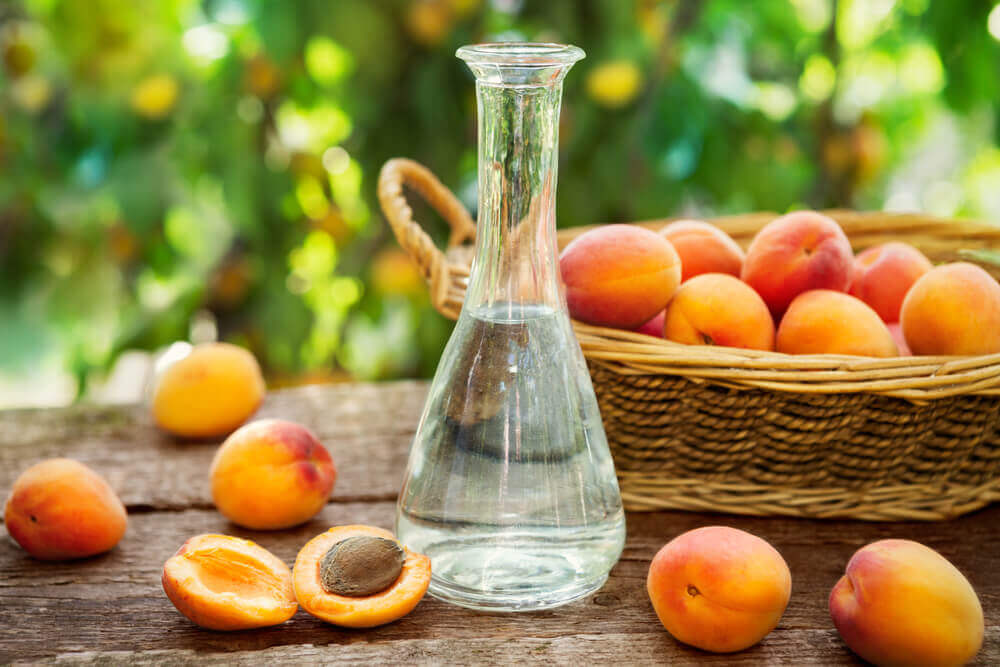 travel to europe. Apricot brandy in a bottle and fresh apricots in wicker basket