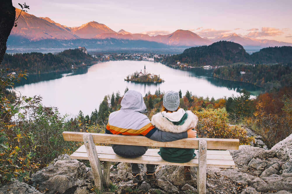 Couple in love looking on Bled Lake. Top view on Island with Catholic Church in Bled. European destinations