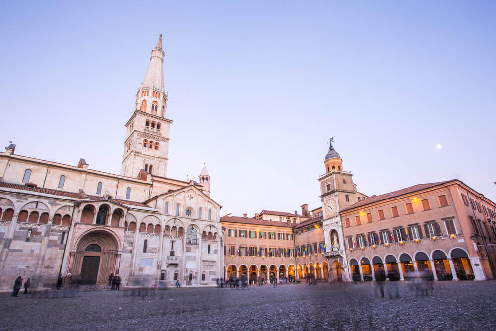 planning a trip to Italy. Modena, Emilia Romagna, Piazza Grande illuminated at sunset, with Cathedral Duomo and Ghirlandina Leaning Tower