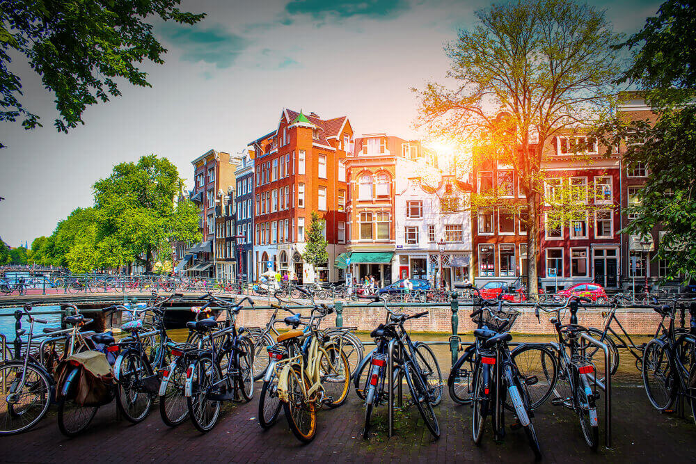 plan a trip to Europe. Parking for bicycles on background of old city at sunset in capital of Netherlands. Streets for walks in Amsterdam