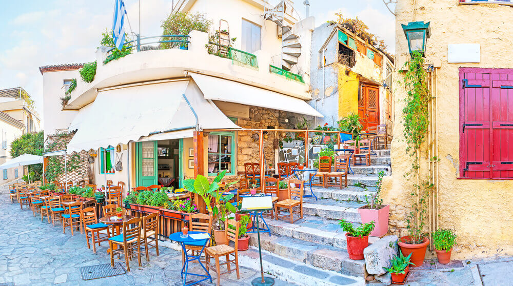 Colourful cafe on cobbled street in Athens. online trip planner.
