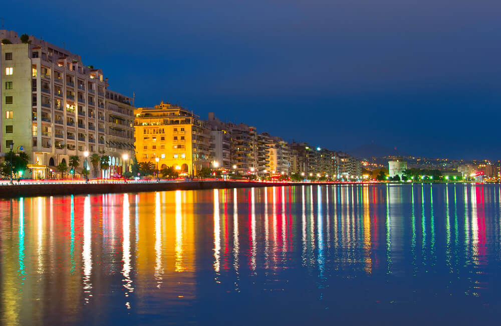 Vibrant night view of Thessaloniki Waterfront with colourful lights reflected in the water. online trip planner.